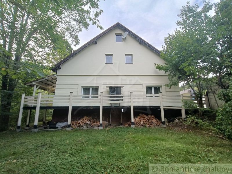 A family house in Staškov, surrounded by greenery, with wood stored under the terrace.