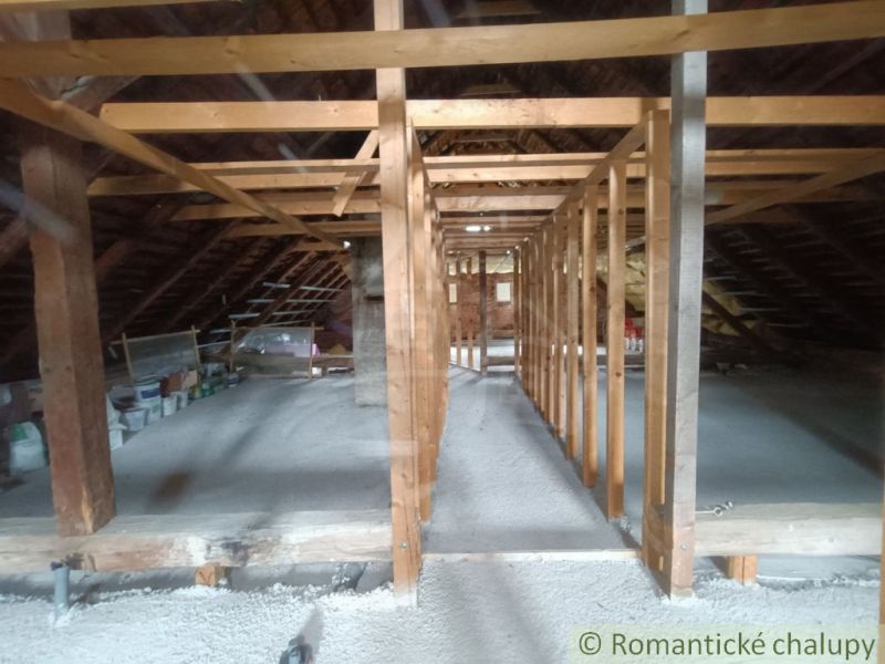 The attic of a family house in Staškov with roof beams and stored items.