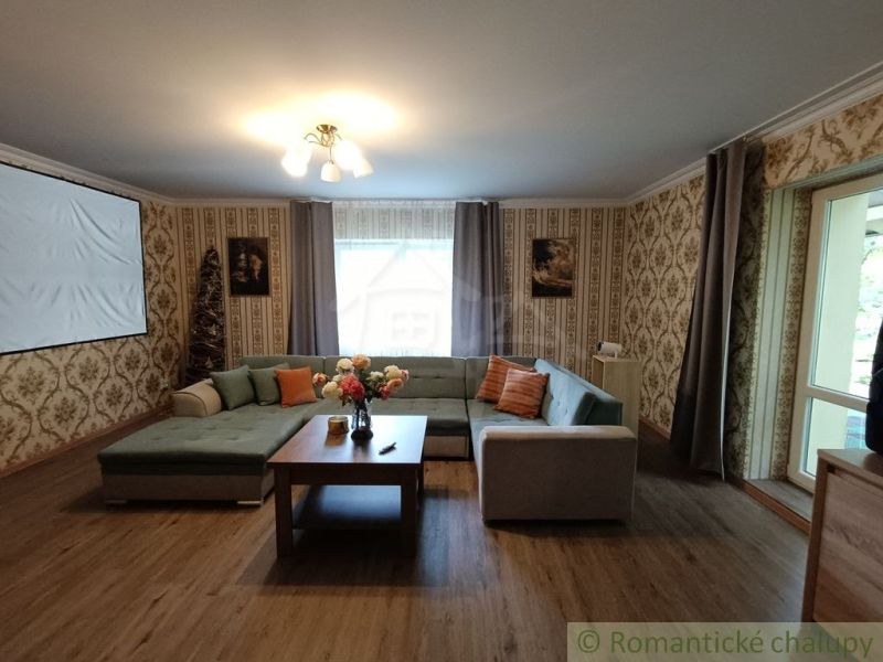 Living room in a family house with a sofa, wooden decor flooring, and a projector.