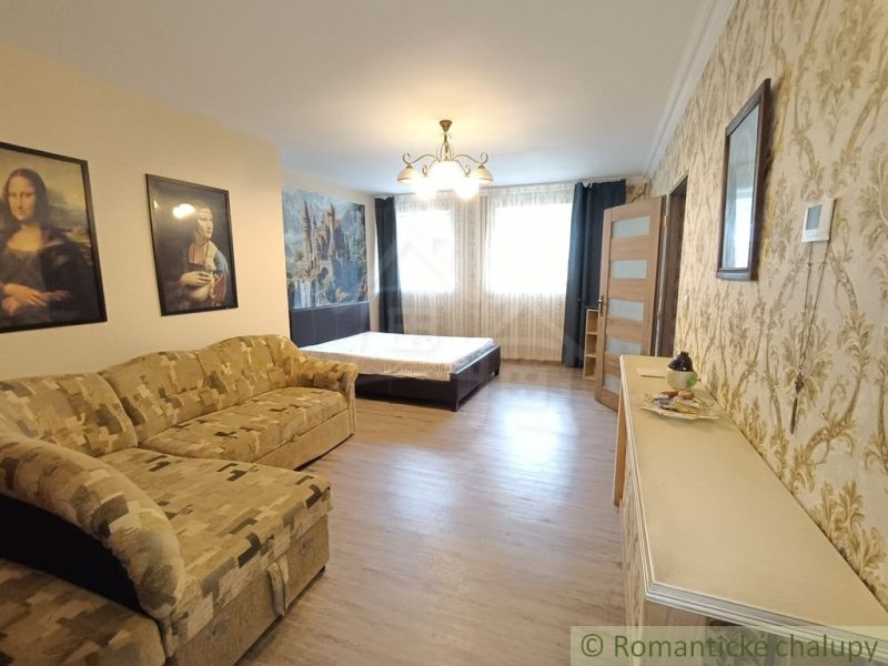 Interior of a family house with a sofa, bed, and wooden decor flooring.
