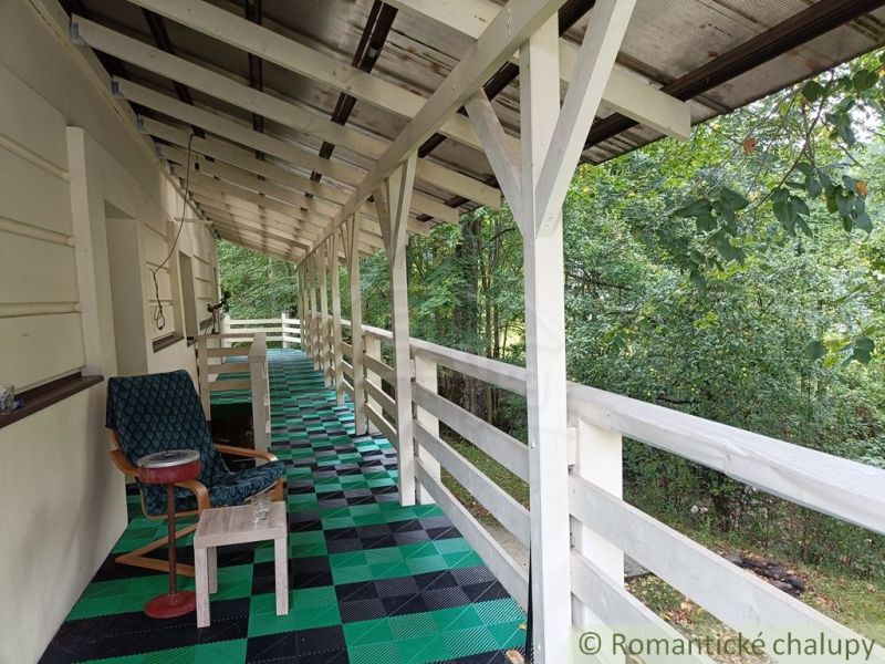 The veranda of a family house in Staškov with a colorful floor and a view of the greenery.