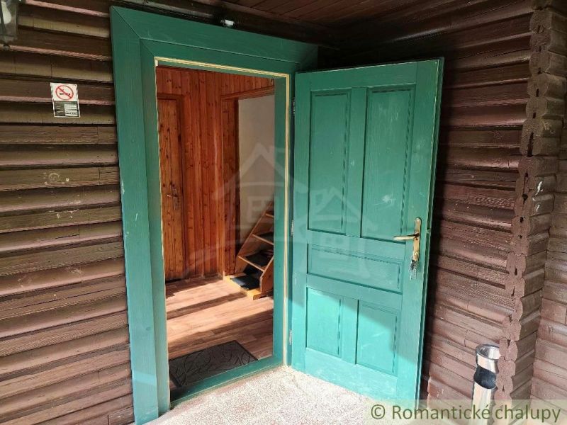 Entrance to a wooden cabin in Rajecká Lesná with open doors and a wooden decor floor.