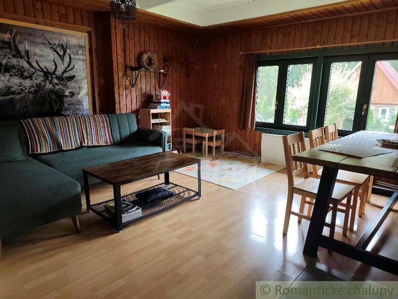 Living room in a cottage with cozy seating and a wooden decor floor.
