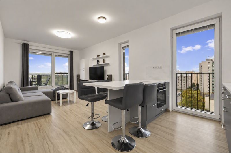 Living room with a kitchenette and a wooden decor floor in a 2-room apartment.