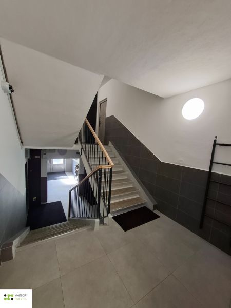 The staircase of an apartment building in a 3-room flat with modern tiles and railing.