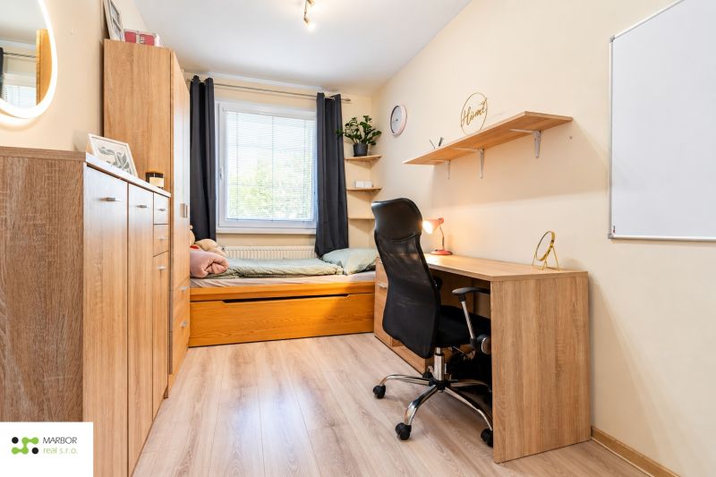 A study with a bed, a desk, and a shelf, a floor with a wooden decor in a 3-room apartment.