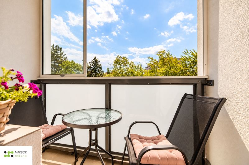 Furnished balcony with a round table and two chairs in a 3-room apartment.
