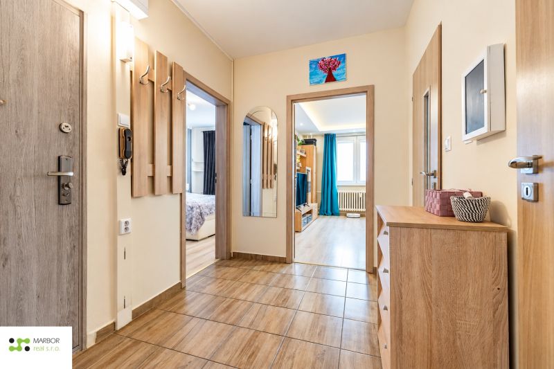 Entrance hallway in a 3-room apartment, bright interior with wood-patterned flooring.