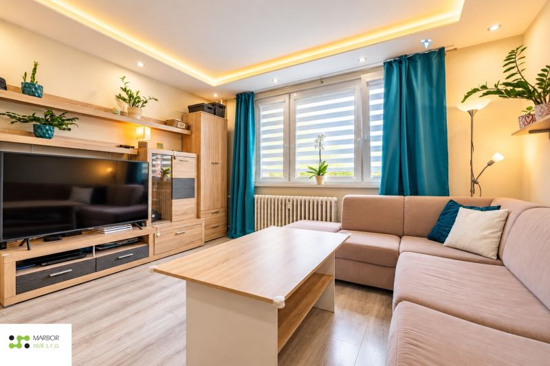 Living room with a sofa set, television, and wooden decor flooring in a 3-room apartment.