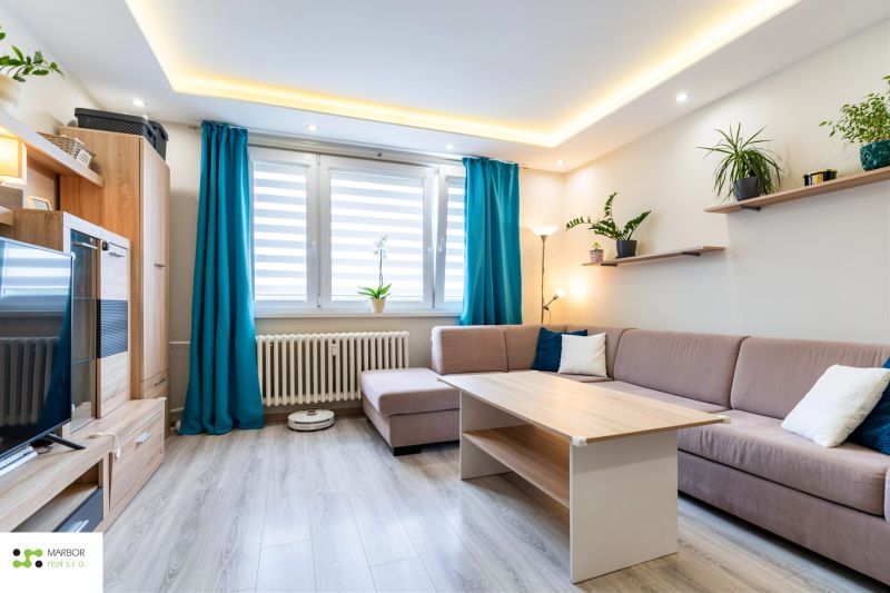Living room in a 3-room apartment with a wooden decor floor and blue curtains.