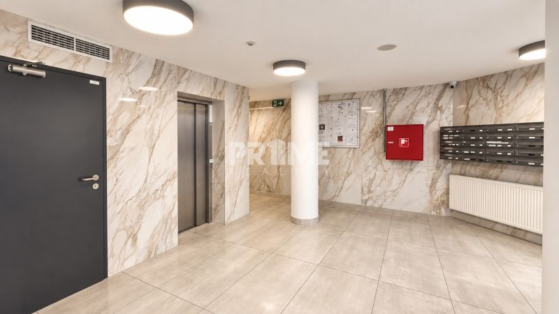 Entrance hall with marble walls, mailboxes, and an elevator in a 2-room apartment.