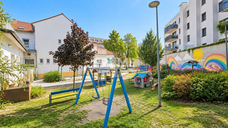 A children's playground surrounded by buildings with colorful murals on Sancova Street.
