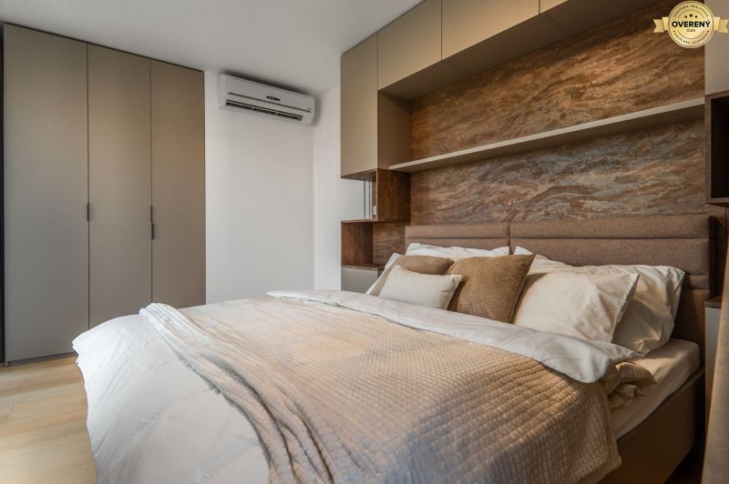 Bedroom with a double bed, built-in wardrobes, and a floor with a wooden decor. Apartment construction.