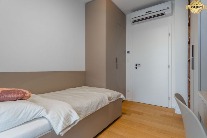 Single room with a bed, built-in wardrobe, and wood-patterned flooring.