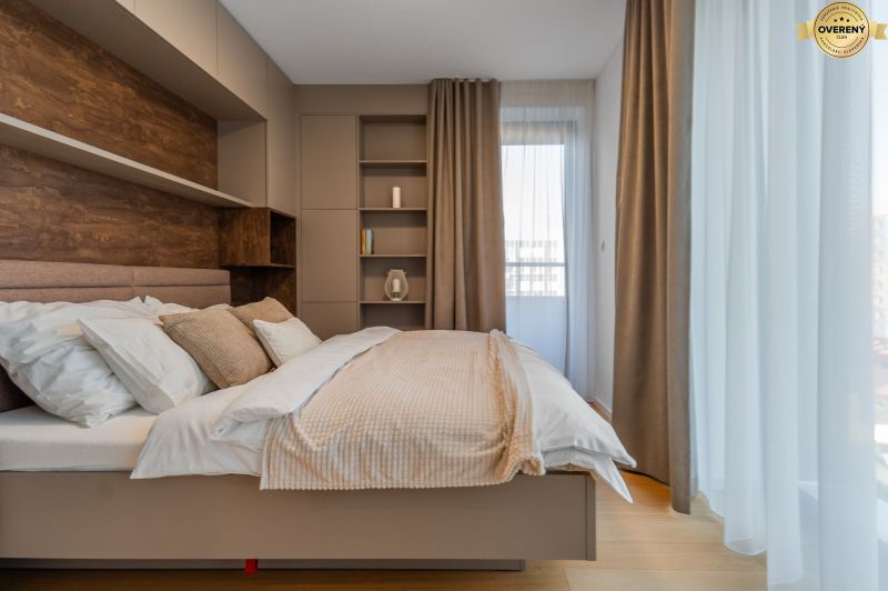 Bright bedroom with beige curtains, shelves, and a wooden decor floor in the apartment construction project.