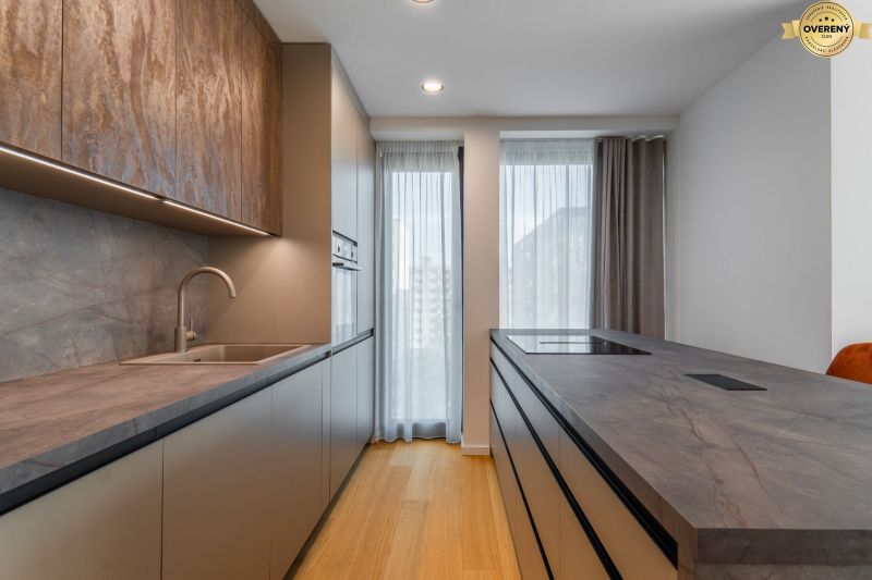 Modern kitchen with wood-patterned flooring and light curtains, Apartment construction.