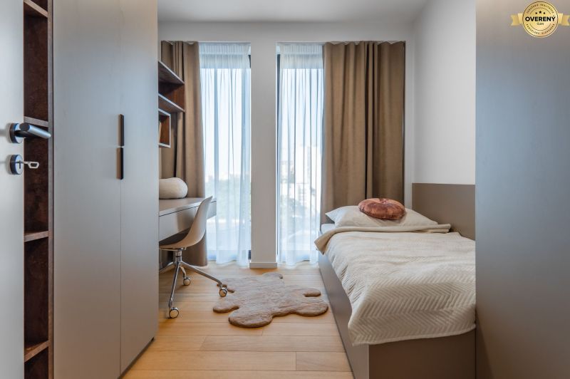 A minimalist room with a bed, a desk, and a wooden floor decor. Apartment construction.