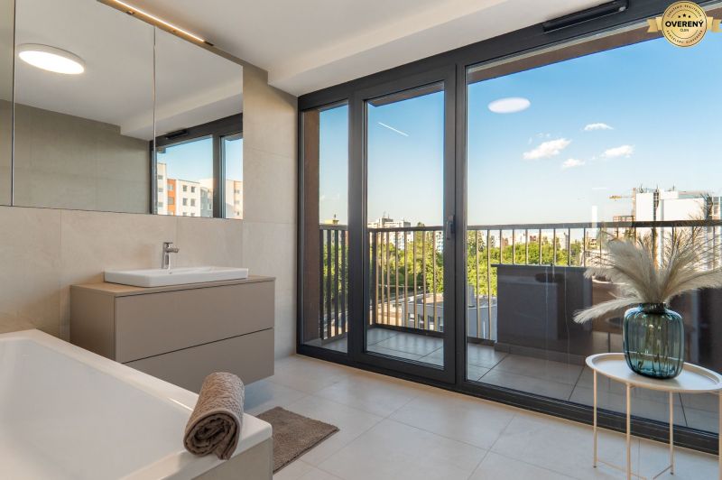 Bathroom with a view and balcony, apartment construction, floor with wood decor.