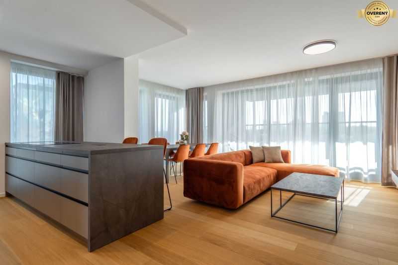 Living room with an orange sofa, wood-patterned floor, and a table in the living room.
