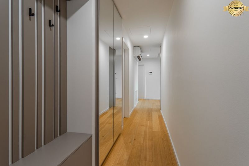 A hallway with a wooden decor floor and a mirrored wardrobe, Apartment construction.