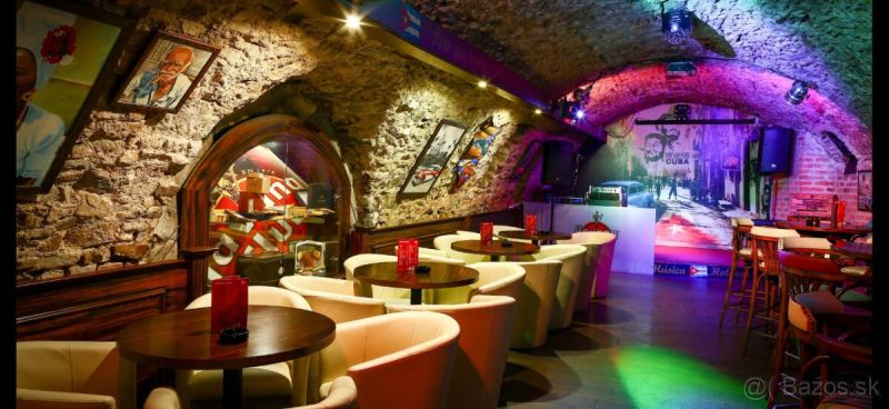 A bar in historical gastro premises with stone walls and a wooden decor floor.