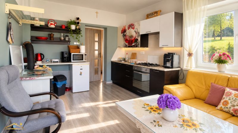 Kitchen and living room in a family house with a wooden decor floor.