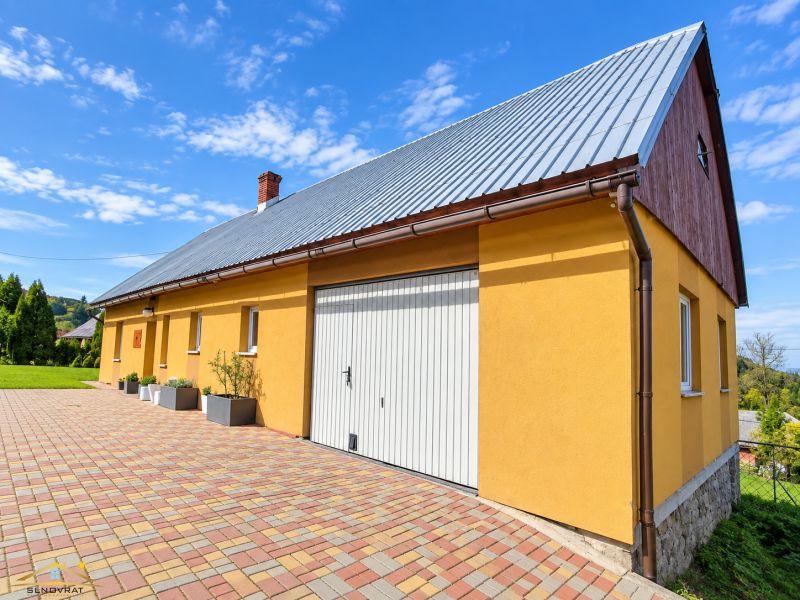 Yellow family house on Košariská Street in Oščadnica with colorful paving.