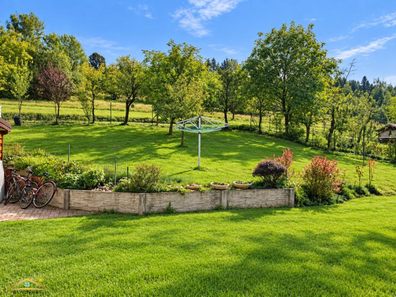 A garden at a family house in Košariská in Oščadnica with a lawn, trees, and shrubs.
