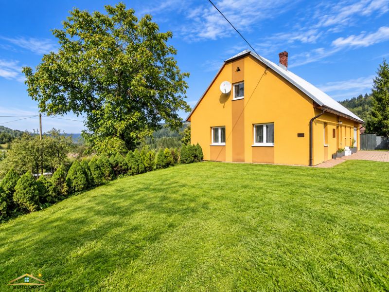 A family house on Košariská Street in Oščadnica surrounded by a large garden and trees.