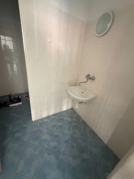 Commercial premises with a sink and blue tiles on the floor.