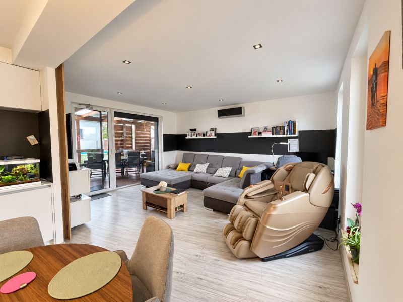 Living room with a massage chair and wooden decor flooring in a family house.