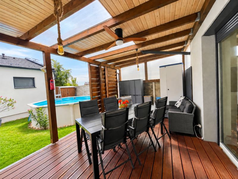 The terrace of a family house in Mosonmagyaróvár with seating and a pool in the garden.