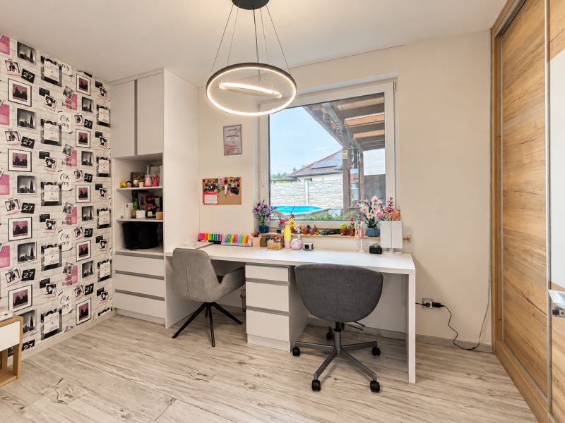 A workspace in a family house with a wooden decor floor, decorative wallpaper.