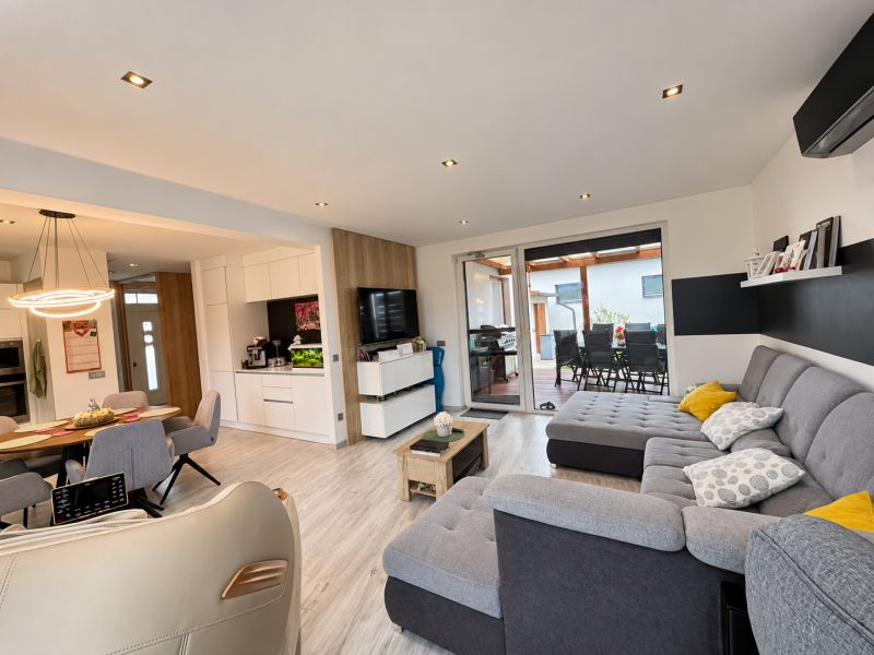 Living room of a family house with a comfortable sofa and open access to the terrace.