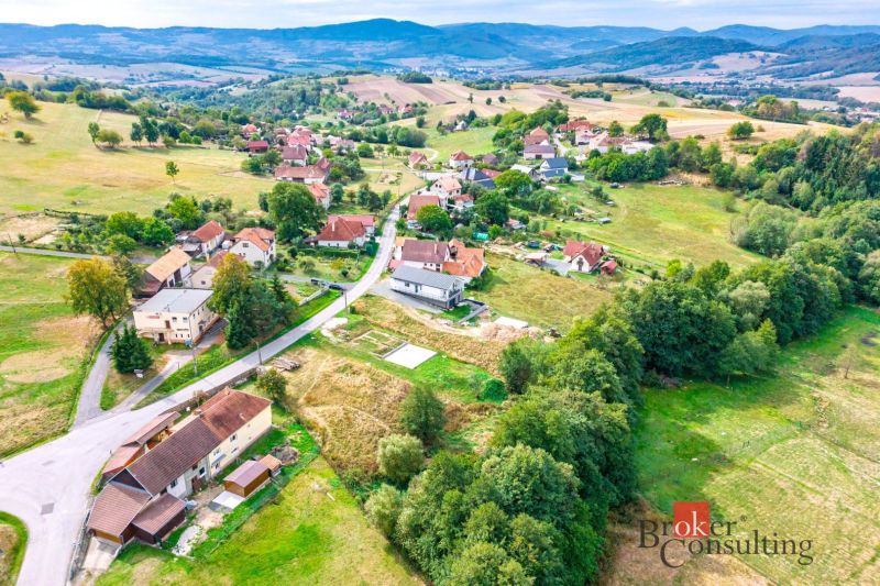 Aerial view of residential plots in the town of Detva with surrounding nature and buildings.