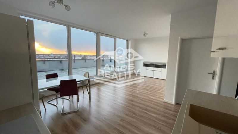 Living room with a dining table, large windows, and a wooden decor floor.