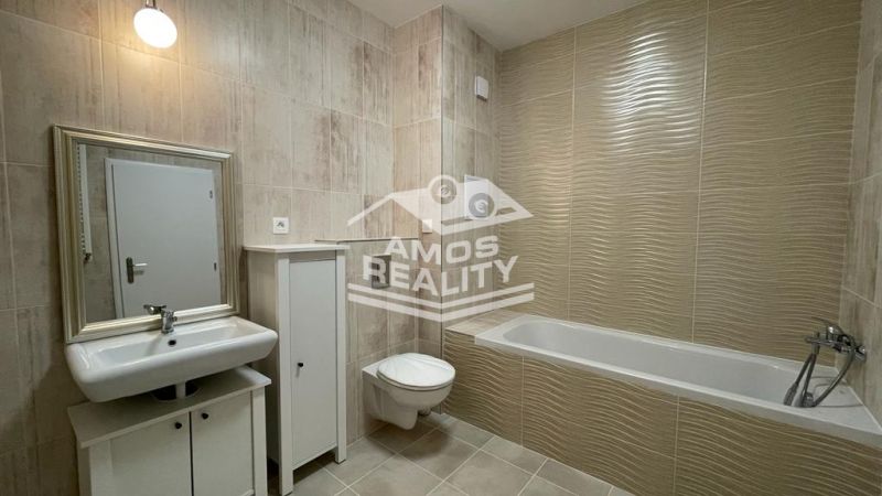 Bathroom in a 2-room apartment with a bathtub, sink, cabinet, and toilet.