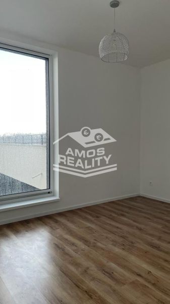 A room in a 2-room apartment with a large window and a floor with a wooden decor.