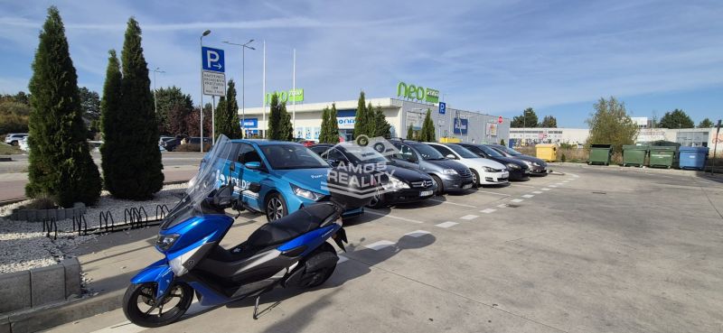 Parking lot with cars and a motorcycle near the shopping center in Malacky on Javorova Street.