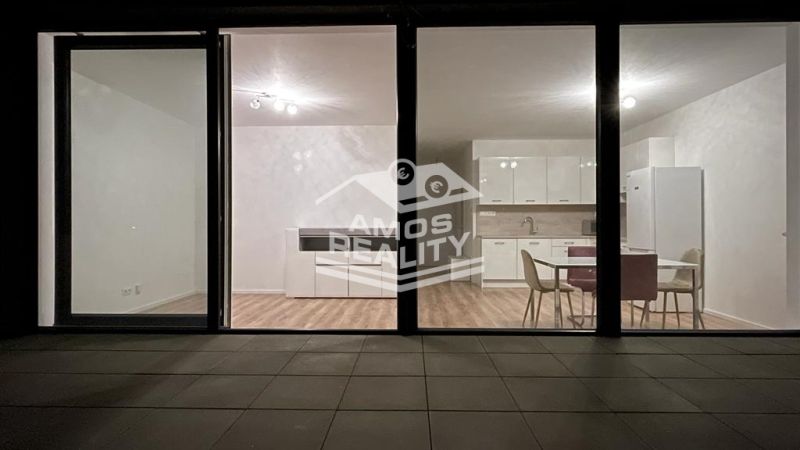 Glass doors leading to the kitchen with wood-patterned flooring in a 2-room apartment.