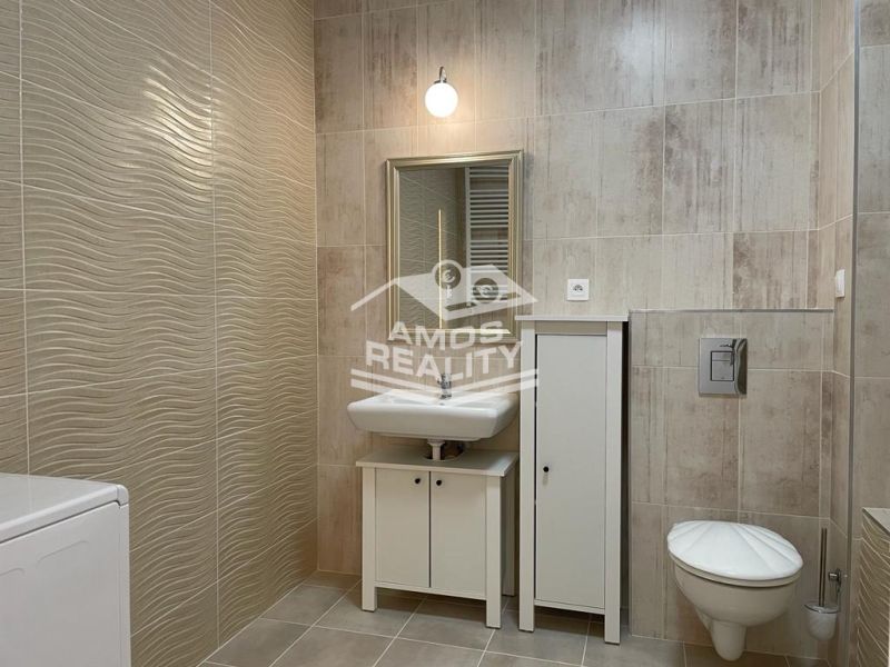 Bathroom in a 2-room apartment with tiles and white sanitary equipment.