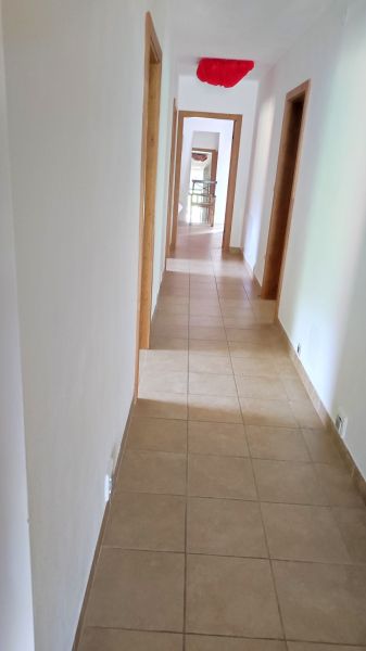 A hallway in a family house with tiles and white walls.