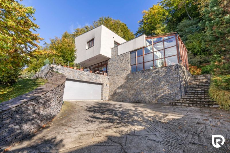 A family house on Karpatská Street in Marianka, surrounded by greenery with a glass terrace.