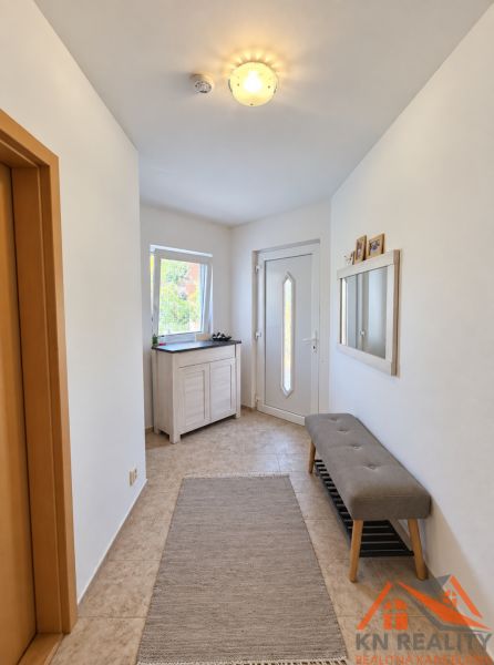 Bright entrance hall in a family house with a bench and a mirror on the wall.