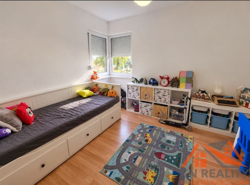 Children's room in a family house with a bed and storage space, floor with wooden decor.