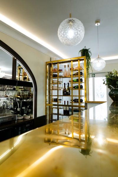 Elegant wine shop and bar in commercial premises with modern lighting and gold details.