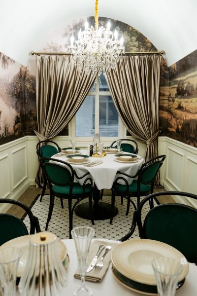 Dining table with luxurious table setting and chandelier in commercial premises.