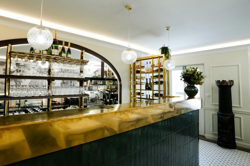 Interior of commercial premises with a shiny bar, hanging glasses, and decorative lighting.