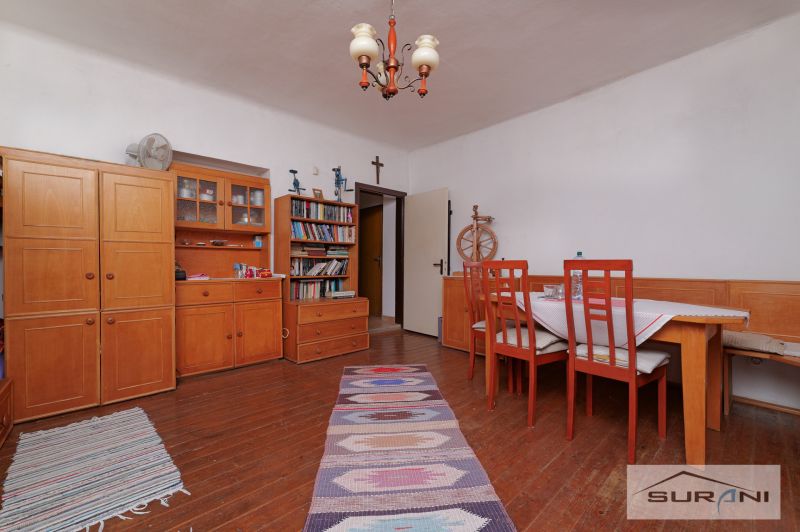 Dining room in a family house with wooden furniture, books, and a floor with a wood decor.