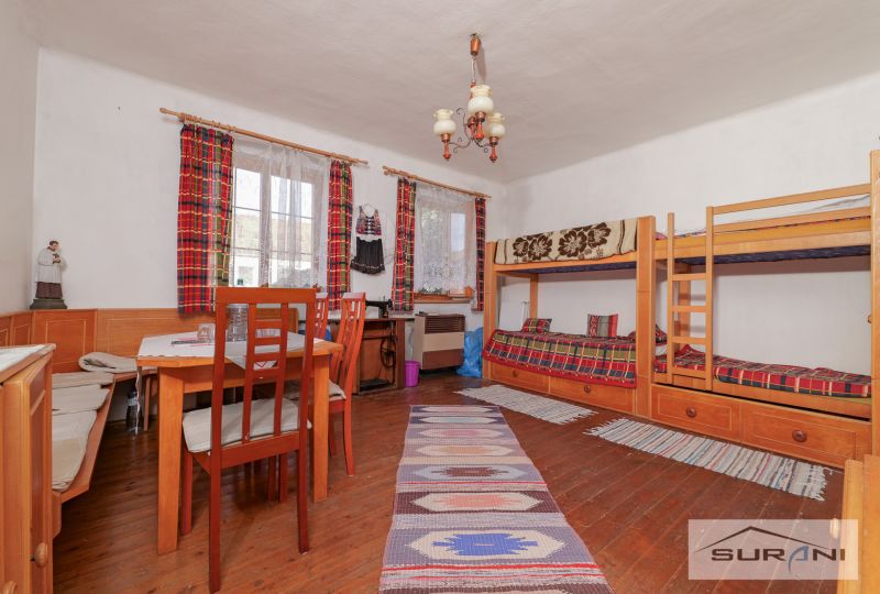In the family house, there is a bunk bed, a table, and a floor with a wooden decor.